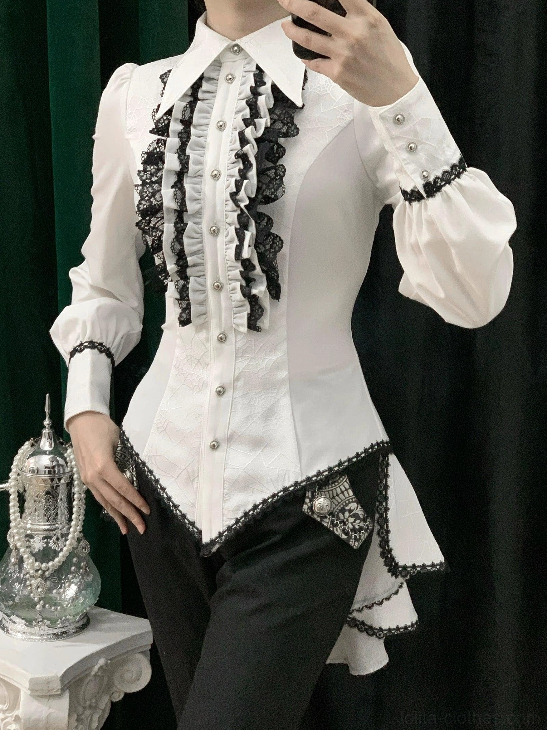 Black and white gothic Ouji lolita shirt front view on model featuring black lace ruffled placket black cuff trim pearl buttons and decorative hip squares