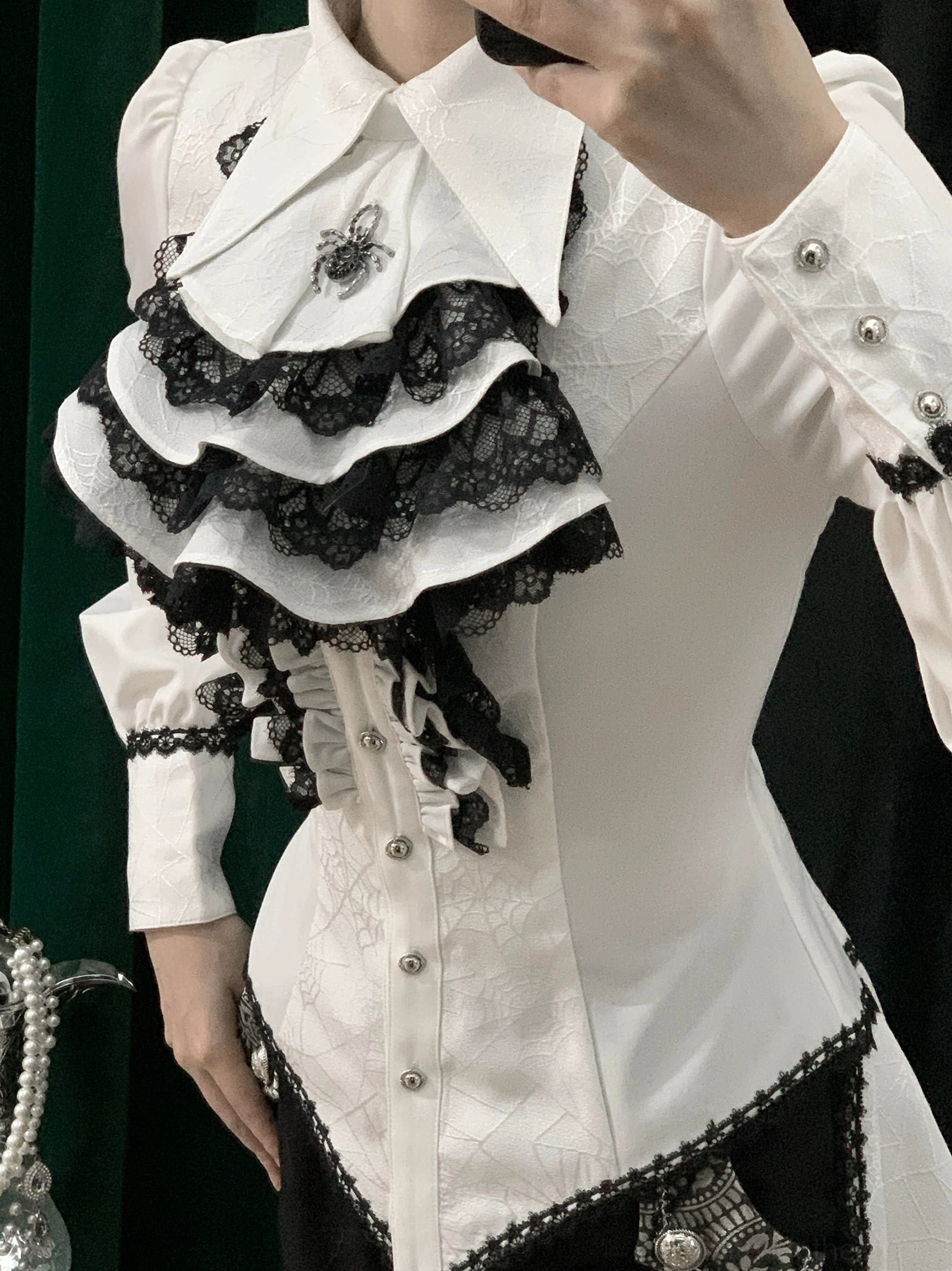 White and black layered lace gothic Ouji lolita shirt close-up front showing multi-layered black lace jabot spider collar brooch and corset fitted silhouette
