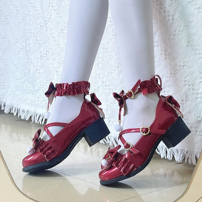 Paint red mid-heel Lolita Mary Jane shoes with butterfly bows and pom-pom accents, side profile view showcasing the block heel and ankle fastening details