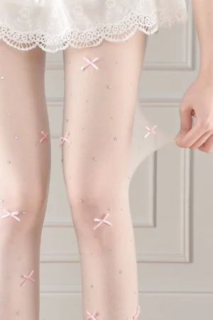 Pale skin tone lolita decorative sheer tights close-up thigh view showing pink bows and rhinestone embellishments elastic stretch fabric