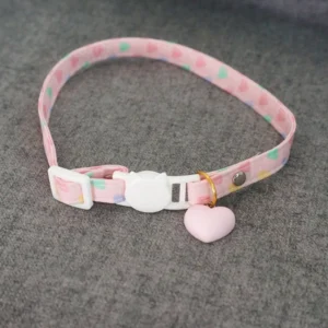 Pastel pink heart charm lolita choker flat lay with multicolor heart print webbing strap white cat safety buckle and 3D matte pink heart pendant with gold jump ring detail