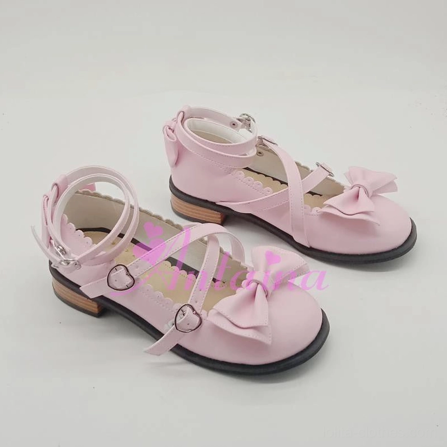 Pastel pink patent leather lolita tea party shoes featuring delicate toe bows, crossover ankle straps with metal buckles, and low block heel - flat lay view