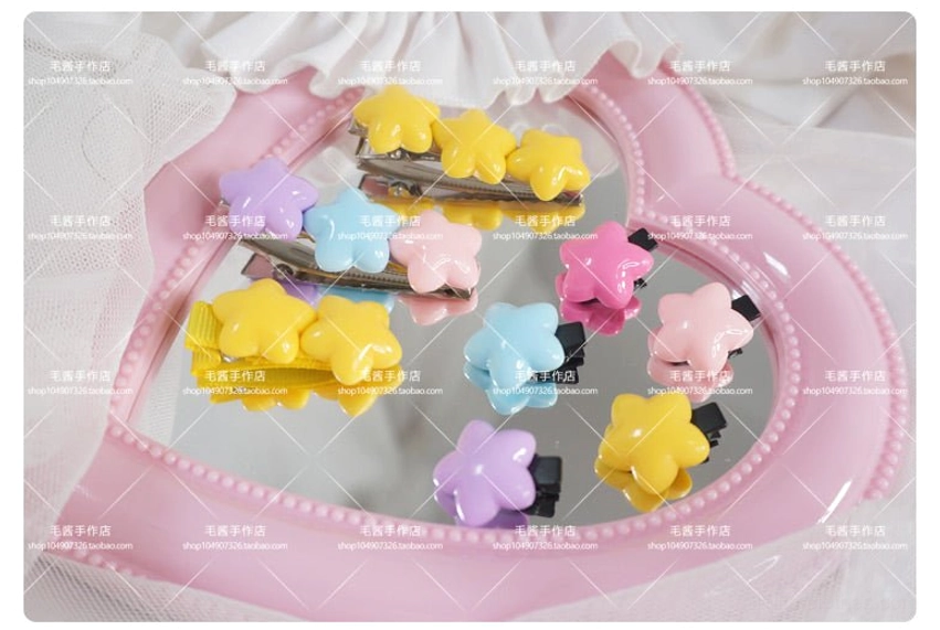 Complete collection of pastel star hair clips in various color combinations displayed on pink heart vanity mirror with lace