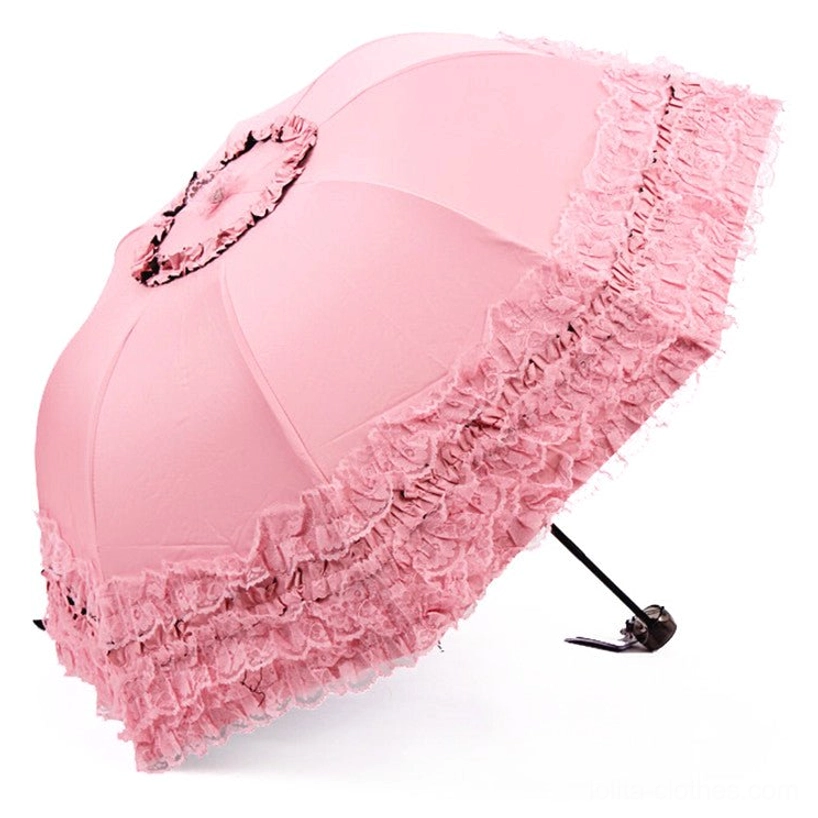 Peach pink foldable sun parasol with thick layered ruffled lace trim and central lace rosette decoration, oblique side profile showcasing delicate details
