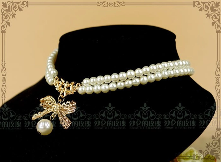 Pearl chain bow lolita choker necklace on mannequin neck display showing proper length fit and styling position, golden bow charm visible placement, white pearl strands, classic lolita accessory wear reference