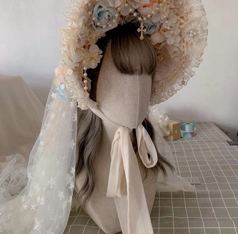 Multi-layer pearl Lolita necklace with rose gold chain, rhinestone accents, and teardrop pendant on fabric mannequin display close-up