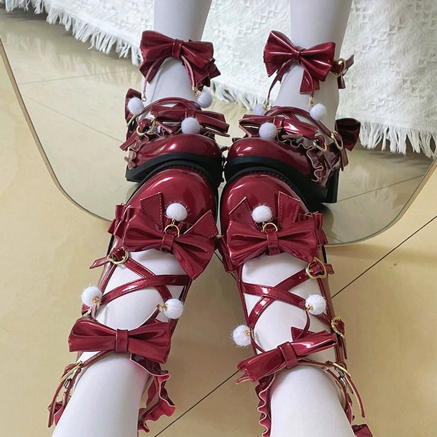 Pearly lustre ivory Lolita Mary Jane shoes with butterfly bow ankle straps and pom-pom accents, studio photography highlighting the glossy pearl finish and design elegance