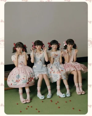 Four Peko lolita girls wearing coordinated sweet lolita JSK dresses in different print variations sitting on studio floor with strawberry props and matching frilled socks