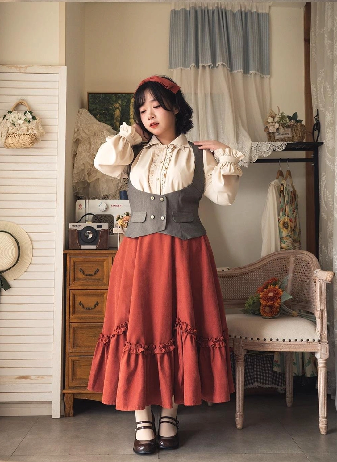 Model in complete vintage Lolita outfit with petal swing orange-red skirt, ivory blouse, fitted grey waistcoat, demonstrating elegant layered coordinate for retro boutique style