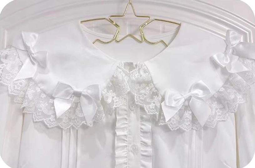 Extreme close-up detail shot of lace ruffled Peter Pan collar with small white satin bows on smooth white polyester fabric of sweet Lolita blouse