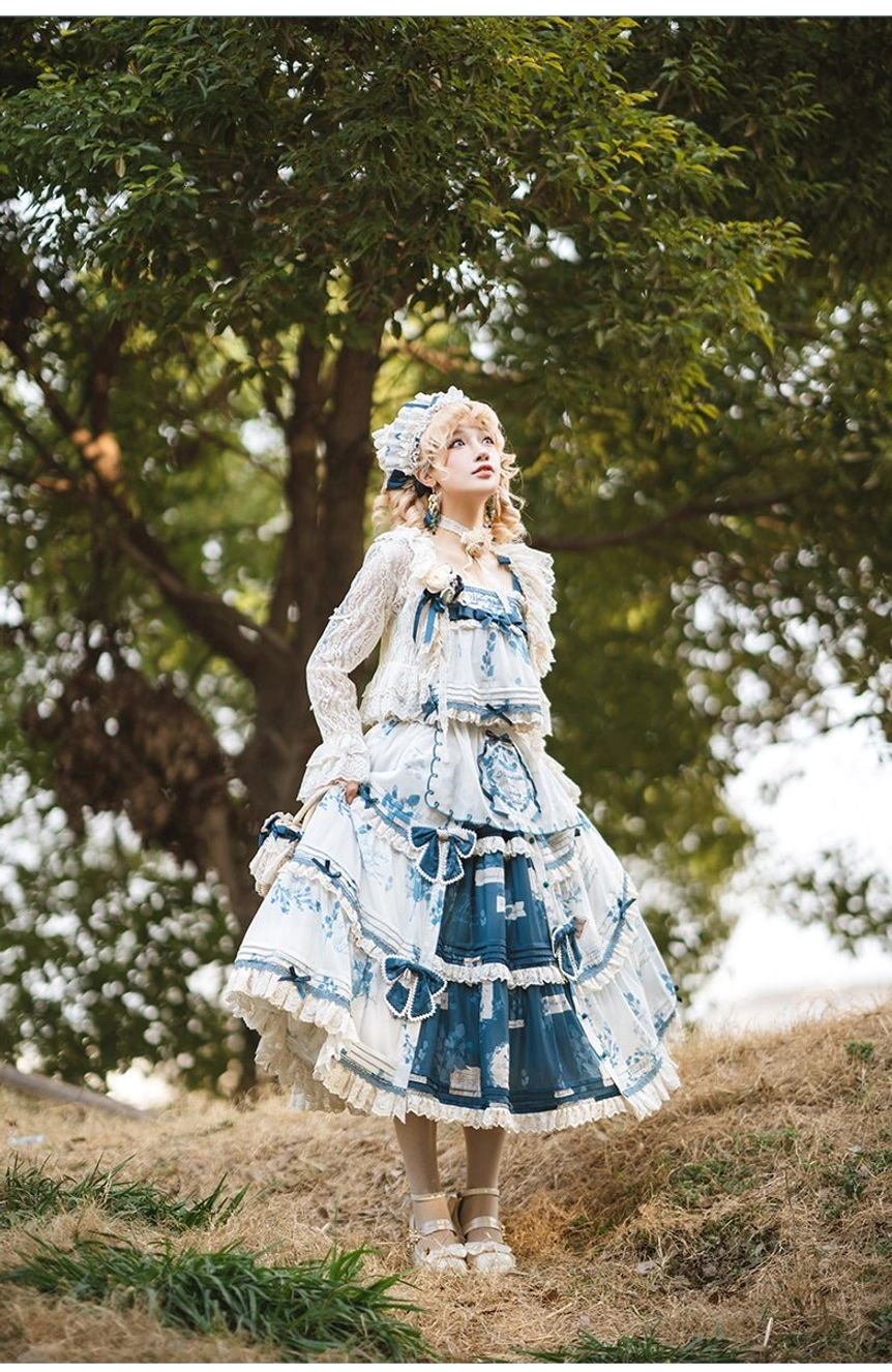 Three-quarter front view of Peter Pan collar Lolita dress with cardigan set, lace long puff sleeves, bow waist details, tiered printed skirt, model wearing size S OP with measurements 150cm height, 44kg weight, bust 76cm, waist 63cm, photographed on grassy woodland ground