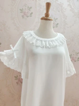 Peter Pan collar sweet lolita inner shirt displayed on dress mannequin featuring round lace ruffle neckline and flutter sleeves with satin bows against vintage floral wallpaper background