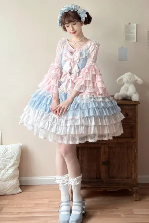 Pink-blue gradient sweet lolita one-piece dress with tiered ruffle cake skirt, trumpet hime sleeves and cross front bow, styled with matching hair accessory in vintage indoor setting