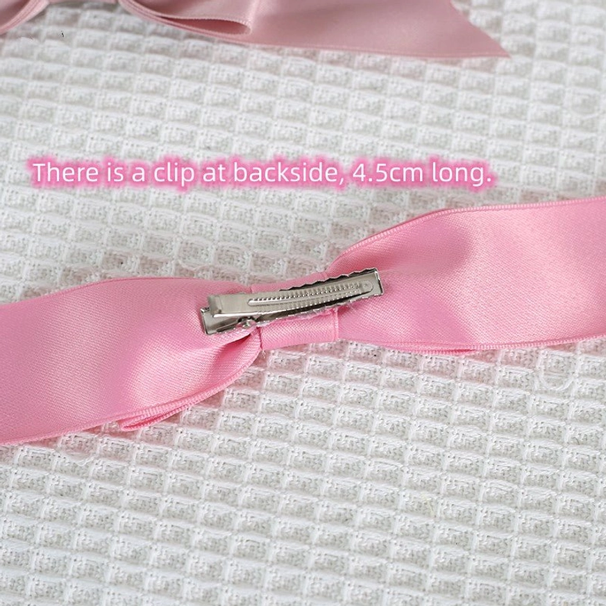Pink satin bow hair clip with alligator mechanism close-up backside showing 4.5cm length measurement and attachment detail