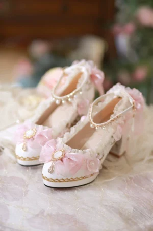 Pink bridal lolita high heel shoes with gold edge trim, white base, pink flower bows, pearl ankle strap - flat lay overhead view