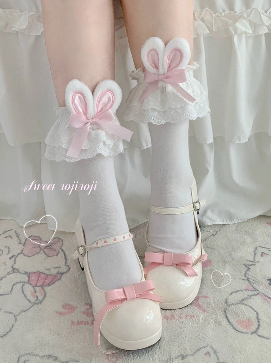 Pink bunny ear sweet lolita socks close-up front view white Mary Jane shoes pink bow straps ruffled lace cuff pastel cartoon background