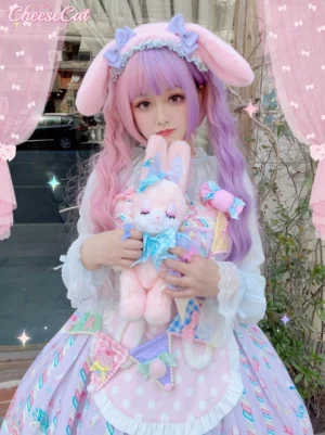 Pink lop-eared bunny lolita hairband with purple decorative bows and ruffled lace trim on purple-haired girl holding plush rabbit outdoor cafe