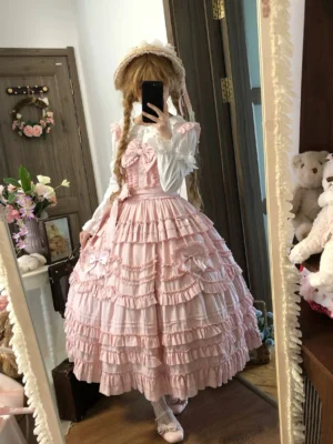 Pink classic lolita JSK dress worn by model with straw bonnet headdress, multi-layered ruffled skirt, shirred bust detail, and matching headband - romantic lolita coordinate inspiration