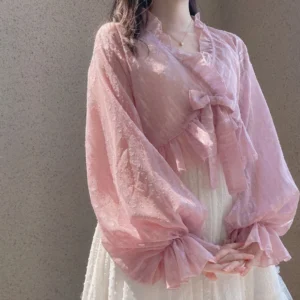 Pink jacquard dotted chiffon puff sleeve sweet Lolita cardigan with ruffled V-neck and detachable front bow worn on model with plain wall background
