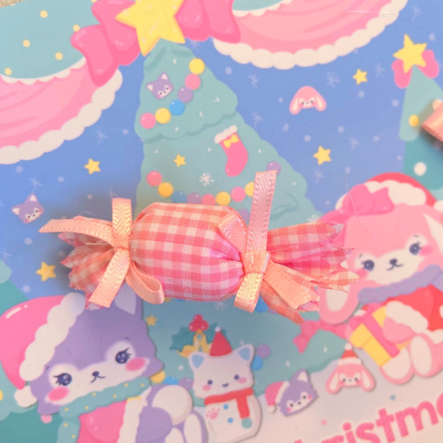 Pink gingham candy lolita hair clip with light pink silk ribbon bows close-up on kawaii Christmas cartoon background, detailed headdress accessory view