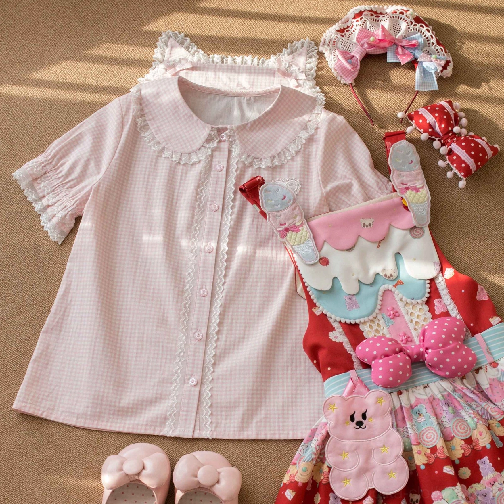 Pink gingham Lolita blouse with Peter Pan collar lace trim and heart embroidery, styled flat lay with printed jumperskirt and sweet Lolita accessories