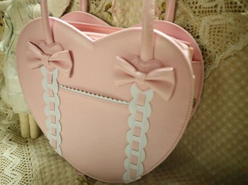 Pink heart-shaped Lolita tote bag close-up overhead front view showing bow details and ribbon trims matte leather