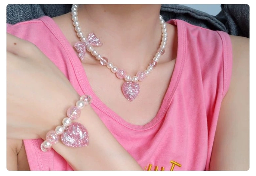 Pink heart glitter charm pearl choker necklace worn on model with sleeveless top showing lolita jewelry styling