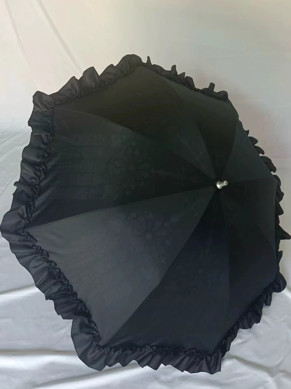 Pink heart-shaped ruffled Lolita parasol with frayed decorative trim and curved handle featuring pompom tip detail, close-up view highlighting romantic embellishments
