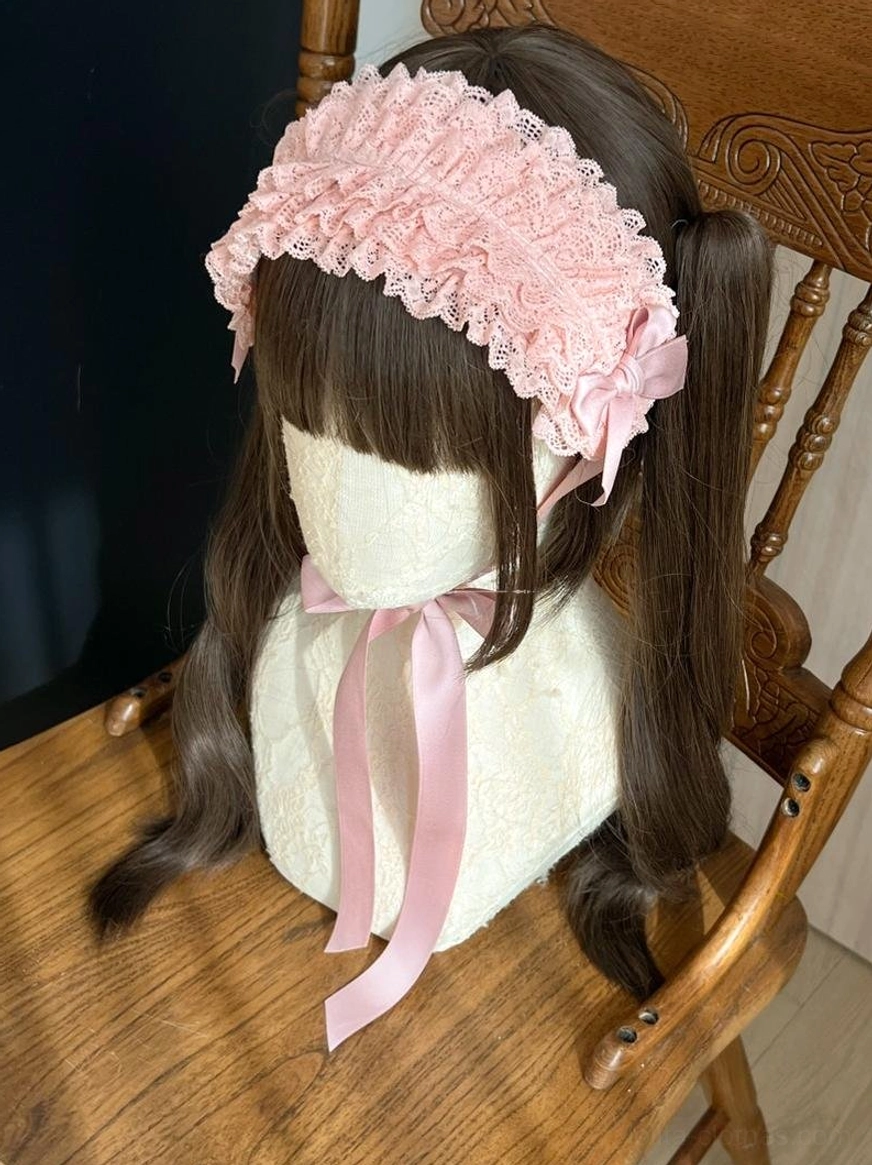 Pink lolita KC headband side profile view showing layered ruffled lace trim, matching pink satin bow, and decorative trailing ribbon on seated mannequin