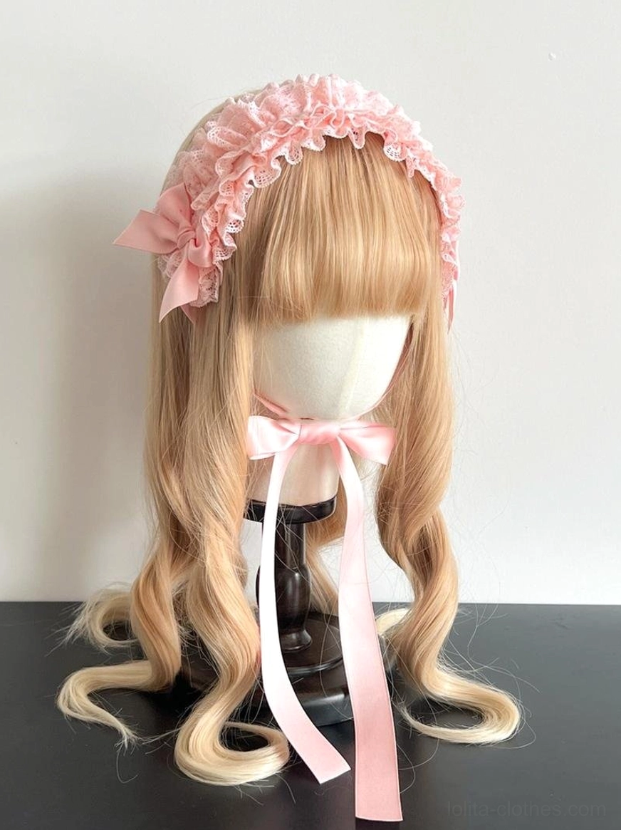 Pink ruffled lace KC headdress front view on mannequin with curly blonde wig in studio setting, displaying elegant lace detail and side satin bow with trailing neck ribbon