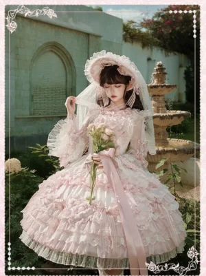 Pink lace lolita bridal dress complete coordinate outdoor garden portrait model wearing matching bonnet veil tiered ruffled skirt