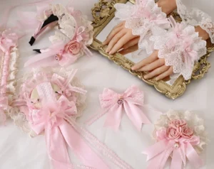Full flatlay collection of pink Lolita lace accessories including headdresses, hairbands, wrist cuffs and hair clips on vintage gold tray