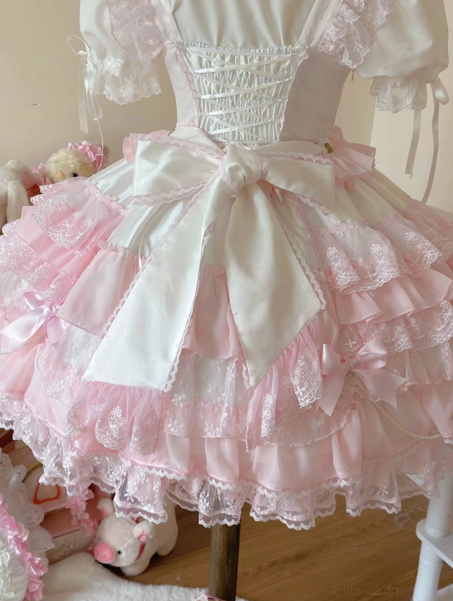 Flat lay of pink lolita bonnet accessory showing construction details and decorative elements for wedding ensemble