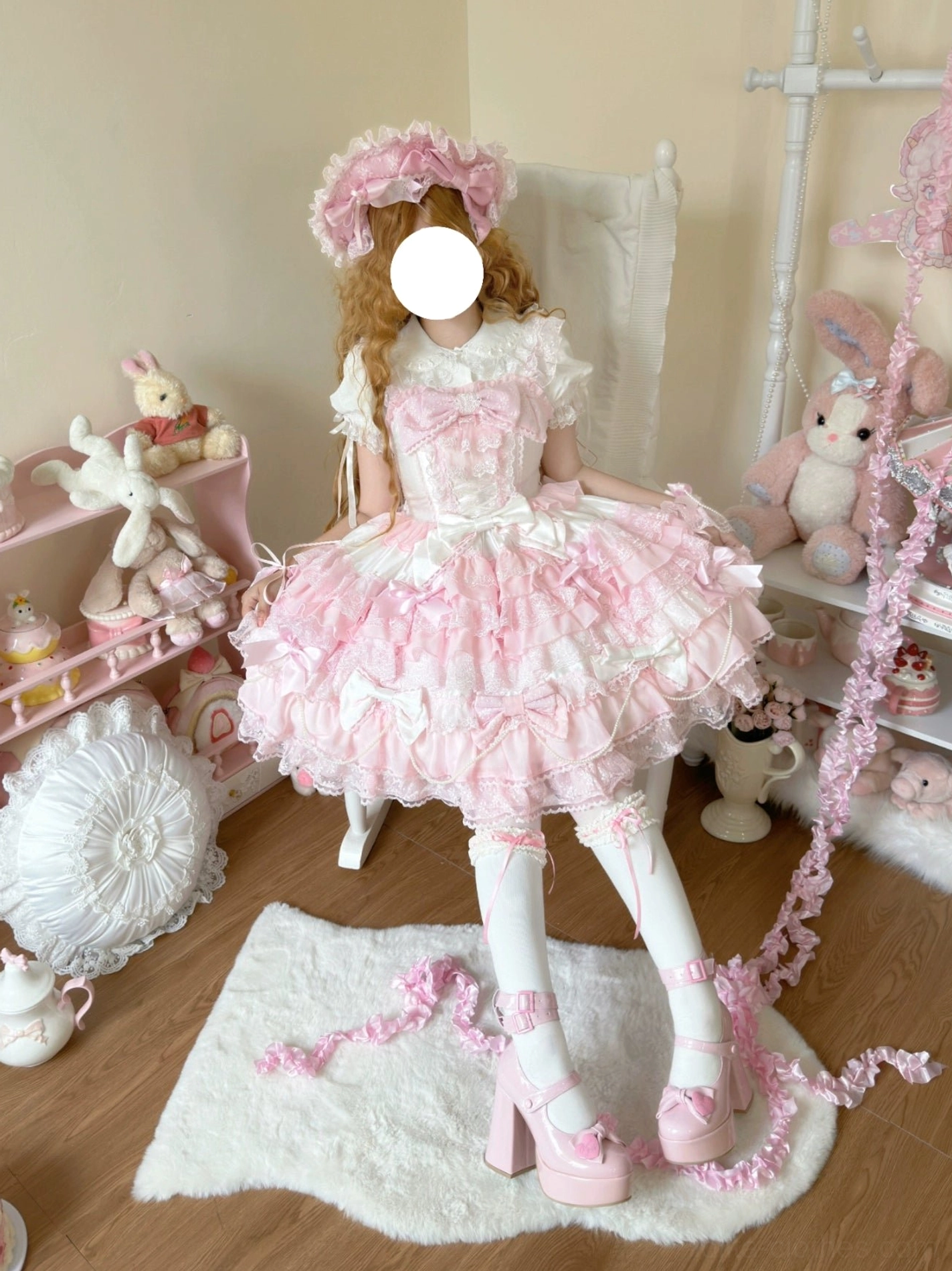 Female model wearing pink lolita dress full-length indoor portrait blurred face white frilled socks pink platform heels tiered lace skirt with bows