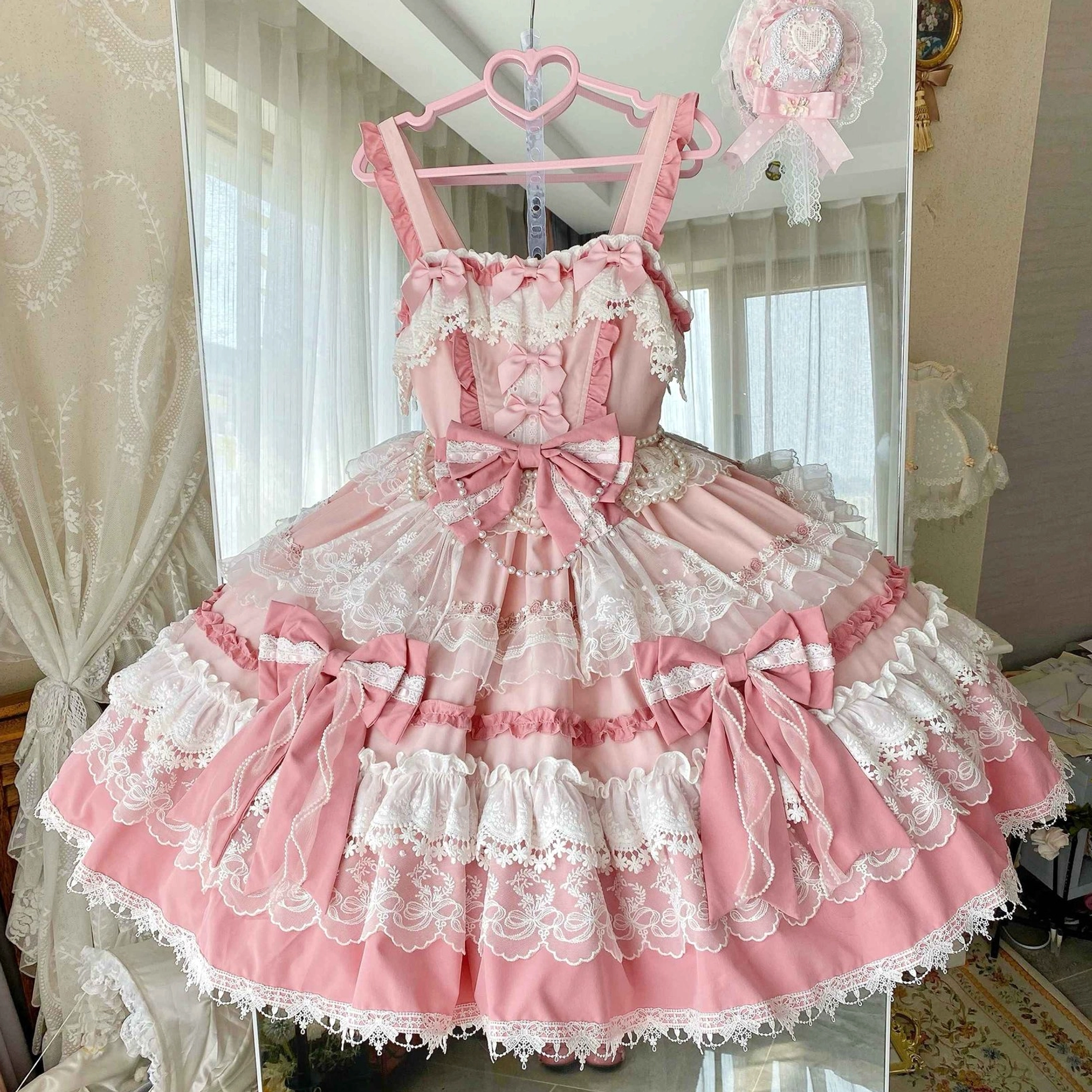 Size comparison of pink lolita jumper dress showing S, M, L sizes on mannequins to demonstrate fit and proportions across different body measurements