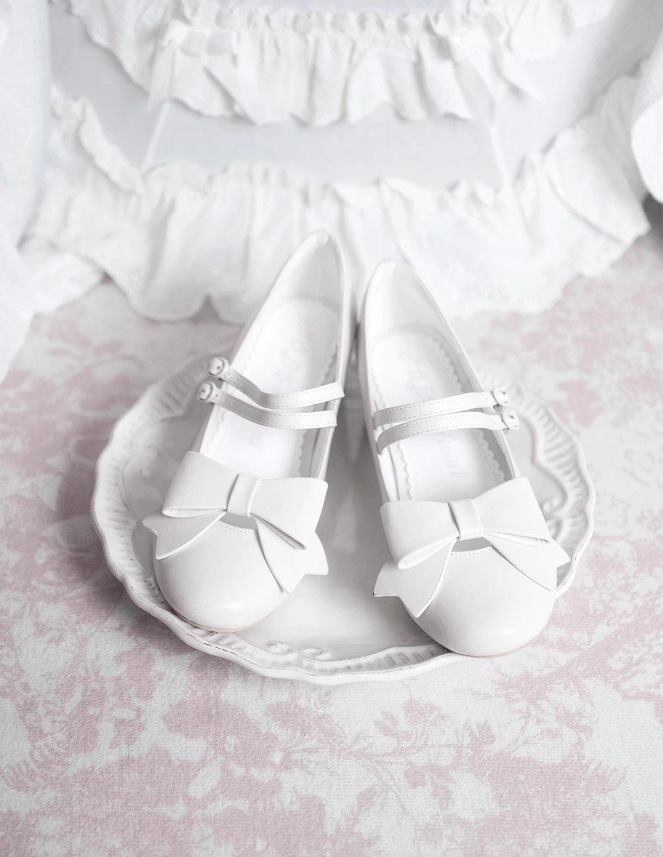 Pink Lolita Mary Jane shoes pointed toe design with decorative bow ankle strap displayed flat lay vintage interior setting sweet Lolita fashion footwear showcase