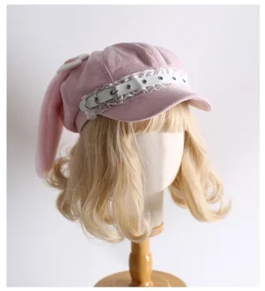 Pink kawaii lolita newsboy cap with detachable plush rabbit ears and wing-heart crown decorations front three-quarter view on blonde wig mannequin display