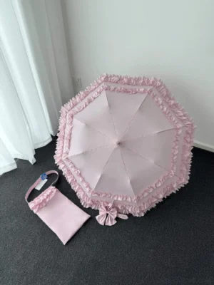 Pink frilled Lolita parasol overhead flat lay view with matching ruffle storage pouch, octagonal canopy with double-layer ruffles and silk bow detail