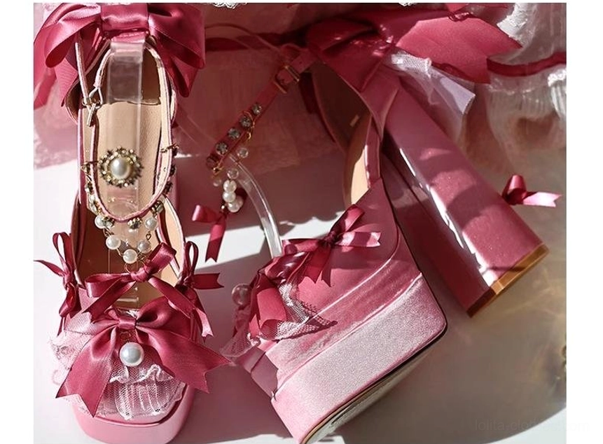 Pink lolita platform heels close-up detail shot showing satin bow construction, platform edge lace trim, and pearl ankle chain elements