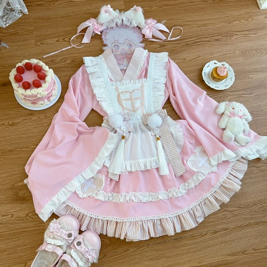 Pink maid lolita dress ensemble flat lay on wooden table with matching shoes cake props plush rabbit showing complete four-piece set