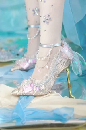 Pink iridescent sweet lolita mermaid heels with gold stiletto heel and sequin toe cap side view on model wearing snowflake stockings