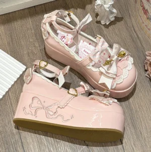 Pink patent leather mousse roll platform sweet lolita shoes three-quarter view showing embroidered bow pattern on side and gold hardware details