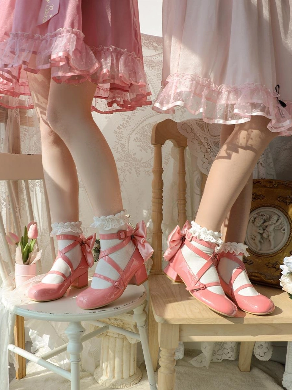 Pink patent leather sweet lolita round toe block heel shoes side view model wearing ruffled socks with bow trim vintage indoor setting flowers