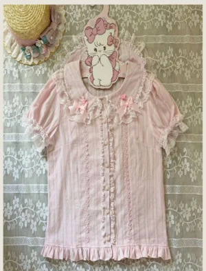 Pink Peter Pan collar lolita blouse front close-up showing ruffled collar trim lace details and heart-shaped button placket on vintage lace background