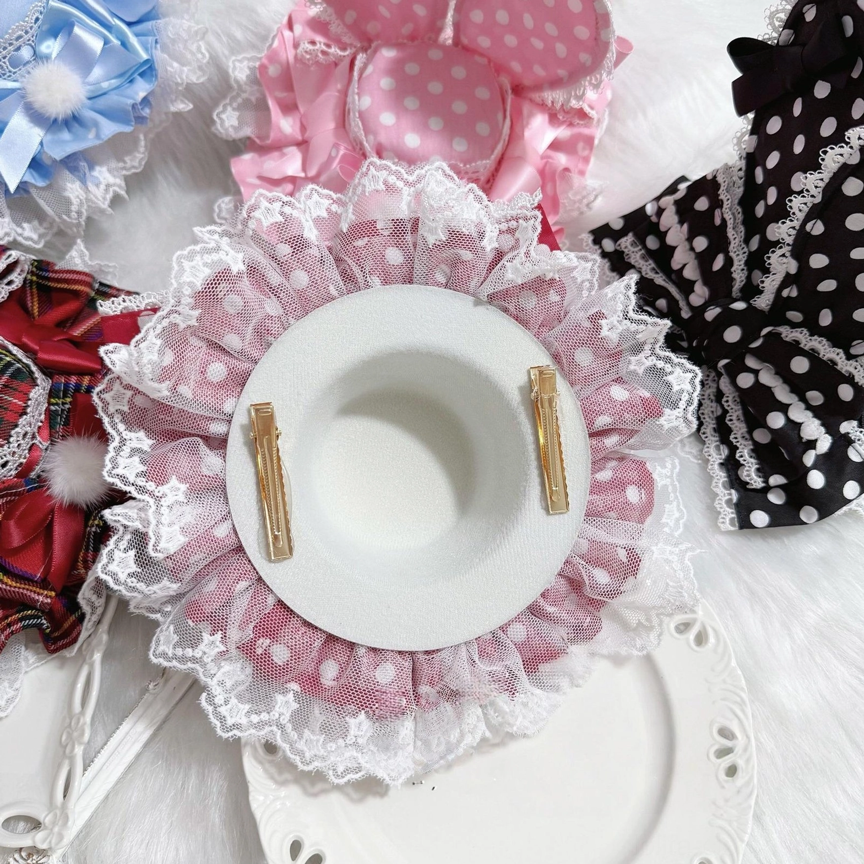 Pink polka dot Lolita bunny ear hair clip headdress flat lay showing dual metal hair clip fasteners, white ruffled lace trim, and coordinating accessories display top-down view