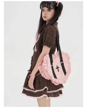 Pink polka dot heart-shaped Lolita JK bag side view with ruffled edges and cross embroidery detail