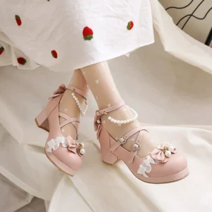 Pink round-toe sweet lolita heels with decorative bow and pearl embellishment, ruffle flower accent on rounded toe, cross buckle straps with heart-shaped fastener, modeled overhead with strawberry-patterned skirt