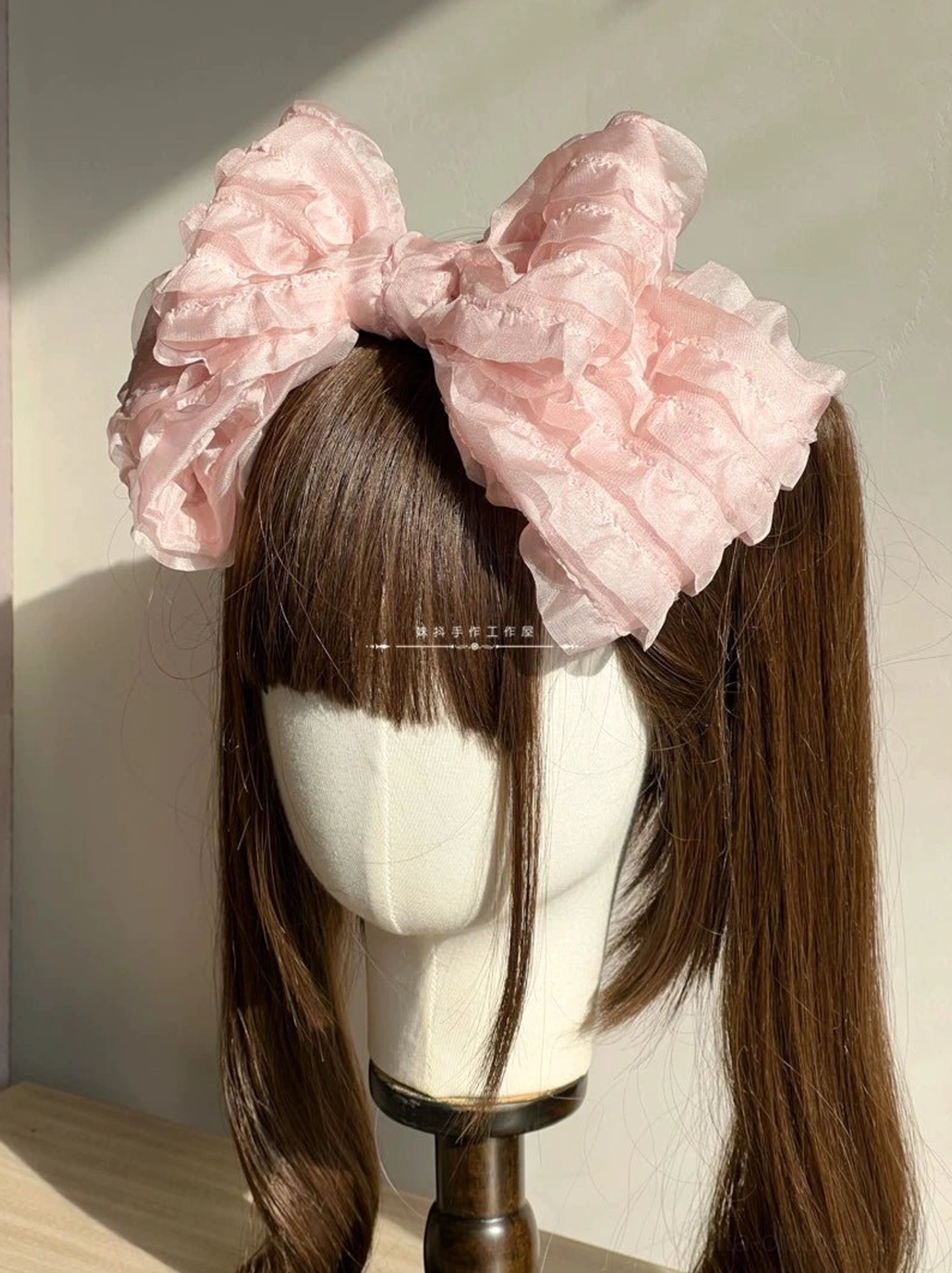 Pink oversized ruffled organza lolita hair clip on single ponytail brown wig mannequin display close-up view