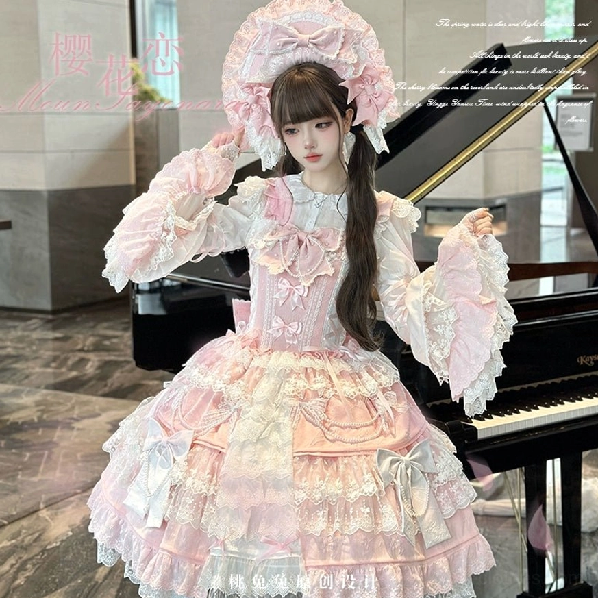 Close-up front three-quarter view of pink Sakura Love lolita dress showing detailed ruffled collar, front bow embellishments, layered satin and lace tiered skirt, oversized bow bonnet detail