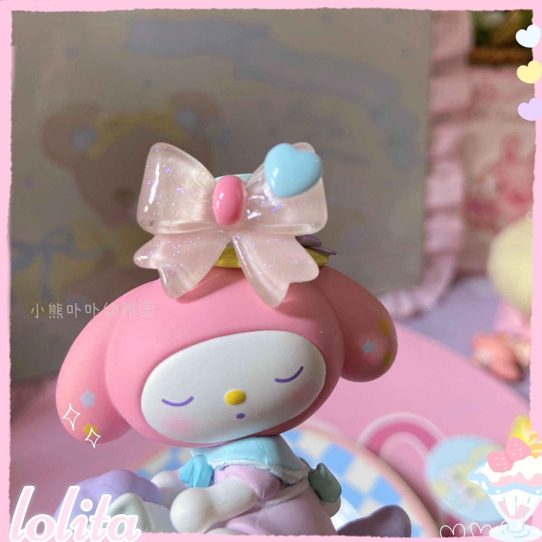 Shimmering pink tulle lolita bowknot ring with pink and blue heart accents displayed on My Melody Sanrio figurine showing delicate cute kawaii design